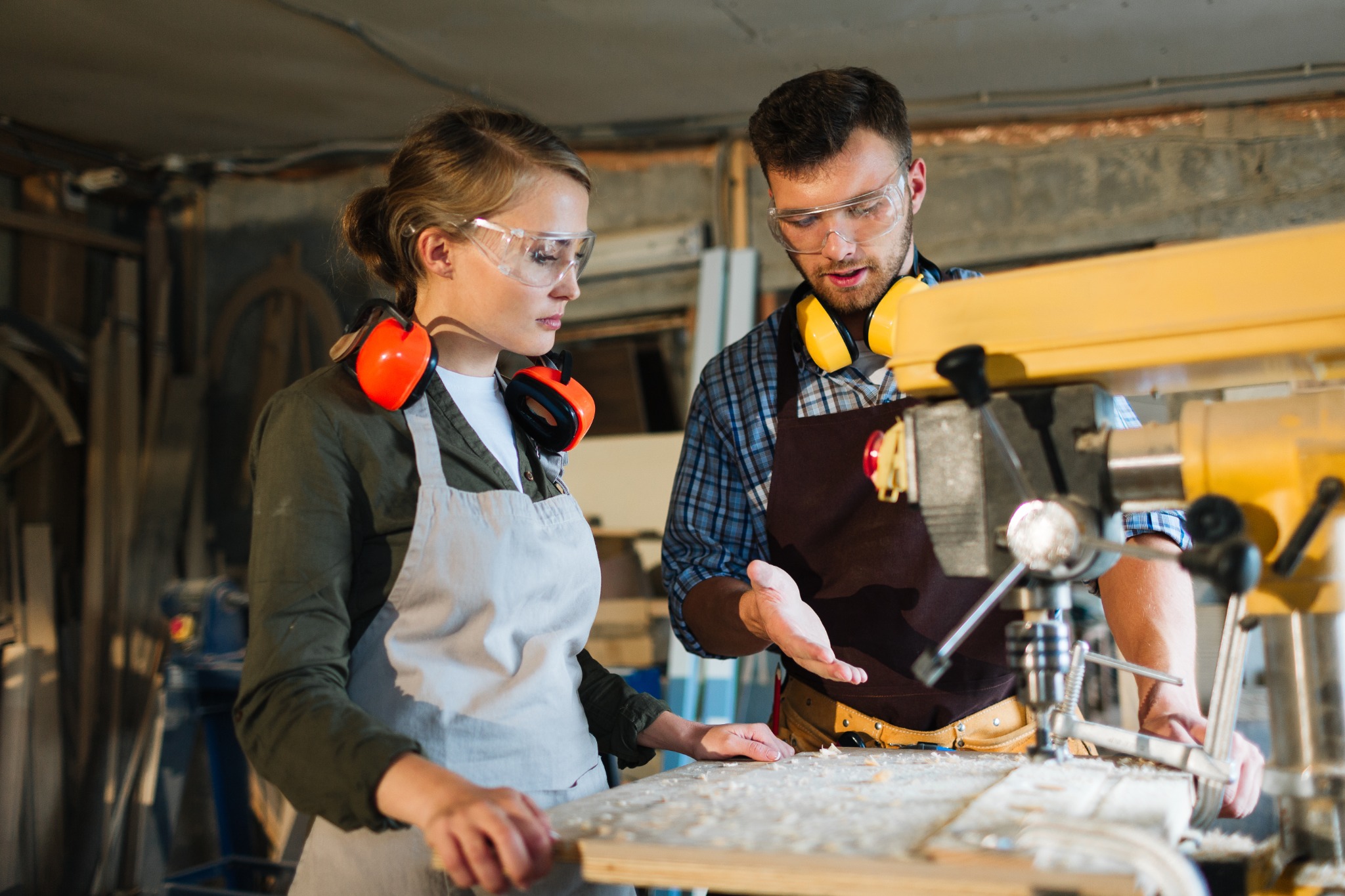 A mentor explaining workshop equipment to a trainee